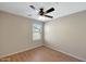 Neutral bedroom with wood-look floors, a ceiling fan, and a view out the window at 129 S 198Th Dr, Buckeye, AZ 85326