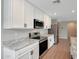 Bright kitchen features stainless steel appliances, white cabinets and stone countertops at 129 S 198Th Dr, Buckeye, AZ 85326
