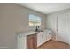 Bright kitchen with stainless steel dishwasher and white cabinets with stone countertops at 129 S 198Th Dr, Buckeye, AZ 85326