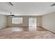 Spacious living room with wood flooring, ceiling fan, and sliding glass door access to yard at 129 S 198Th Dr, Buckeye, AZ 85326
