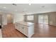 Open-concept living room and kitchen area with island, wood flooring, and ceiling fan at 129 S 198Th Dr, Buckeye, AZ 85326