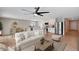 Bright, open-concept living room with modern decor, ceiling fan, and stainless steel appliances at 129 S 198Th Dr, Buckeye, AZ 85326