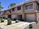 Multi-story townhome with attached garages, private patios, desert landscaping, and terracotta roofs at 1633 E Lakeside Dr # 38, Gilbert, AZ 85234