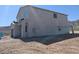 Side view of a two-story stucco home with a garage and a balcony on an unfinished lot at 3835 W Fox Rd, Laveen, AZ 85339