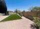 Wide shot of backyard showing artificial grass, gravel, desert landscaping, and patio at 6049 E Glencove St, Mesa, AZ 85205