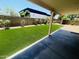 View of the backyard with artificial grass, a block wall, and a covered patio at 6049 E Glencove St, Mesa, AZ 85205