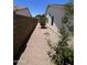 Narrow side yard with gravel, desert landscaping, block wall, and home exterior at 6049 E Glencove St, Mesa, AZ 85205