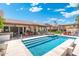 Expansive backyard featuring a sparkling pool, covered patio, outdoor kitchen, and lounge area at 7722 E Hartford Dr, Scottsdale, AZ 85255