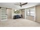 Spacious living room with carpet flooring, featuring a TV, dresser and sliding barn door at 7722 E Hartford Dr, Scottsdale, AZ 85255