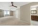 View of large main bedroom with bathroom and closet access, ceiling fan, and large window at 7722 E Hartford Dr, Scottsdale, AZ 85255