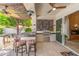 Inviting outdoor kitchen with stainless steel grill, bar seating, and travertine flooring, perfect for entertaining at 7722 E Hartford Dr, Scottsdale, AZ 85255