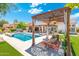 Beautiful backyard pool area with outdoor seating, pergola, and lush landscaping on a sunny day at 7722 E Hartford Dr, Scottsdale, AZ 85255