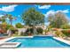 Refreshing swimming pool with decorative water feature and landscaping, creating a tranquil backyard oasis at 7722 E Hartford Dr, Scottsdale, AZ 85255