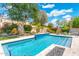 Sparkling pool with lush landscaping, a tranquil water feature, and a cozy fire pit, perfect for outdoor enjoyment at 7722 E Hartford Dr, Scottsdale, AZ 85255