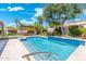 Beautiful swimming pool with a baja step, elegant landscaping, and a shaded lounge area at 7722 E Hartford Dr, Scottsdale, AZ 85255