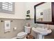 Neat half-bathroom with a pedestal sink, dark wood trim, and tasteful decor at 1237 E Marcella Ln, Gilbert, AZ 85295