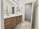 Bathroom with a double sink vanity, well-lit mirror, and tiled flooring at 1237 E Marcella Ln, Gilbert, AZ 85295