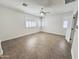Bright, empty bedroom featuring plantation shutters, a ceiling fan, and tile flooring at 1237 E Marcella Ln, Gilbert, AZ 85295