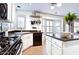 Well-lit kitchen featuring white cabinetry, black countertops, and stainless steel appliances and utensils at 1237 E Marcella Ln, Gilbert, AZ 85295