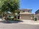 Two-story home with desert landscaping, large shade tree and two car garage at 17394 W Pima St, Goodyear, AZ 85338