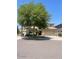 Two-story home with desert landscaping, large shade tree and two car garage at 17394 W Pima St, Goodyear, AZ 85338