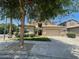 Two-story home with desert landscaping, large shade tree and two car garage at 17394 W Pima St, Goodyear, AZ 85338