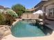 Beautiful backyard swimming pool with rock features and desert landscaping at 17394 W Pima St, Goodyear, AZ 85338