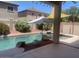 Backyard swimming pool with rock features, a small spa and desert landscaping at 17394 W Pima St, Goodyear, AZ 85338