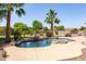 Resort-style pool area with rock waterfall feature, palm trees, and lush landscaping creating a tranquil backyard oasis at 19515 E Via Del Palo --, Queen Creek, AZ 85142