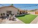 Spacious backyard with green grass, covered patio, and ample seating for outdoor entertaining at 4010 W Mariposa Grande --, Glendale, AZ 85310