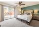 Bright main bedroom features a ceiling fan, a large bed, and sliding glass doors to the outside at 4010 W Mariposa Grande --, Glendale, AZ 85310