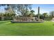 Landscaped community sign on lush green lawn, featuring desert plants and mature trees in a desirable neighborhood at 6556 N Arizona Biltmore Cir, Phoenix, AZ 85016