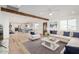 Bright, open-concept living room featuring modern furnishings, wood beam, and hardwood floors at 20815 N 119 Th Ave, Sun City, AZ 85373