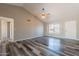 Spacious living room with vaulted ceilings, a ceiling fan, wood-look floors and a front-facing window at 4906 E Evergreen St, Mesa, AZ 85205