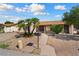 Charming single-story home featuring desert landscaping and mature palm trees on a sunny day at 5120 W Willow Ave, Glendale, AZ 85304