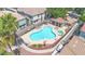 Aerial view of a community pool with lounge chairs, umbrellas, and nearby playground with a sand area at 7533 S 31St Pl, Phoenix, AZ 85042