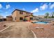 View of the backyard featuring a pebble-tec pool, desert landscaping, and covered patio for entertaining at 10551 W Jessie Ln, Peoria, AZ 85383