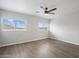 A bright bedroom features a ceiling fan, wood-look floors and two windows to provide natural light at 10551 W Jessie Ln, Peoria, AZ 85383