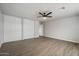 This bedroom provides ample closet space with wood-look floors and a ceiling fan at 10551 W Jessie Ln, Peoria, AZ 85383