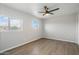 This bedroom boasts a unique octagon window with wood-look floors and a ceiling fan at 10551 W Jessie Ln, Peoria, AZ 85383