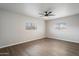 This bedroom offers wood-look floors, neutral paint, and a ceiling fan with views to the front yard at 10551 W Jessie Ln, Peoria, AZ 85383