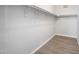 Walk-in closet featuring painted white walls and trim, wood grain vinyl flooring, and a sturdy metal shelving system at 10551 W Jessie Ln, Peoria, AZ 85383