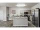 Modern kitchen with an island, granite countertops, and stainless steel appliances at 10551 W Jessie Ln, Peoria, AZ 85383