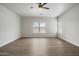 Large, open living room featuring wood floors, a ceiling fan, and one large window at 10551 W Jessie Ln, Peoria, AZ 85383