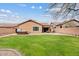 Large backyard with a green lawn, brick patio, and a hot tub, perfect for outdoor living at 10603 E Firewheel Dr, Scottsdale, AZ 85255