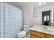 Bright bathroom featuring a toilet, mirror and a white and blue patterned shower curtain at 10603 E Firewheel Dr, Scottsdale, AZ 85255