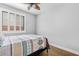 Comfortable bedroom with a ceiling fan, wood floors, and a window with stylish white shutters at 10603 E Firewheel Dr, Scottsdale, AZ 85255