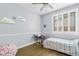 Light-filled bedroom with wood-style floors, window shutters, and cloud-shaped shelving at 10603 E Firewheel Dr, Scottsdale, AZ 85255