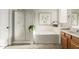 Bright bathroom features a glass-door shower, soaking tub, a large mirror, and double sinks at 10653 E Lindner Cir, Mesa, AZ 85209
