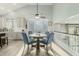 Dining area with glass table, four chairs, vaulted ceiling, and large window allowing for plenty of natural light at 10653 E Lindner Cir, Mesa, AZ 85209